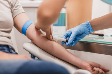 Close up of person donating blood in a hospital setting 